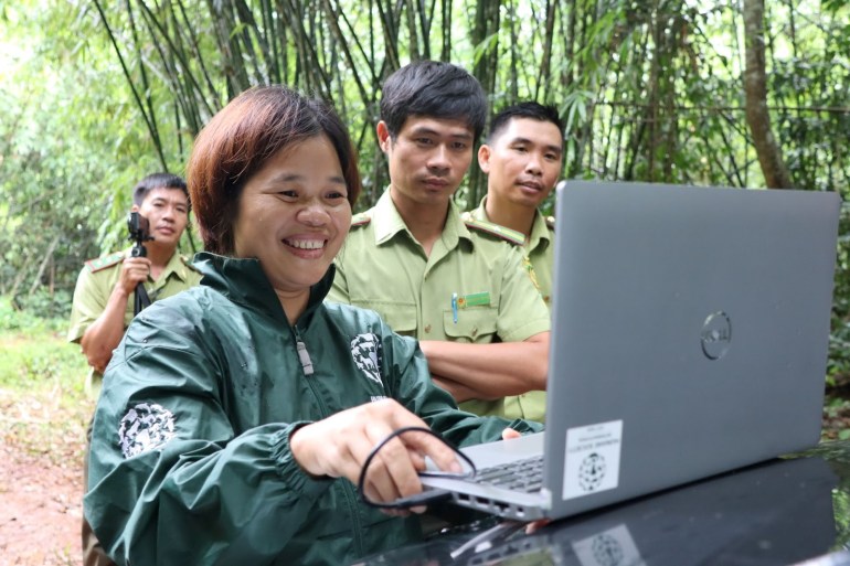 Nguyen Thi Mai shows forest officials photos taken from a camera trap near Cat Tien National Park.  He has been training them on how to install and use camera traps. [Sen Nguyen/Al Jazeera]