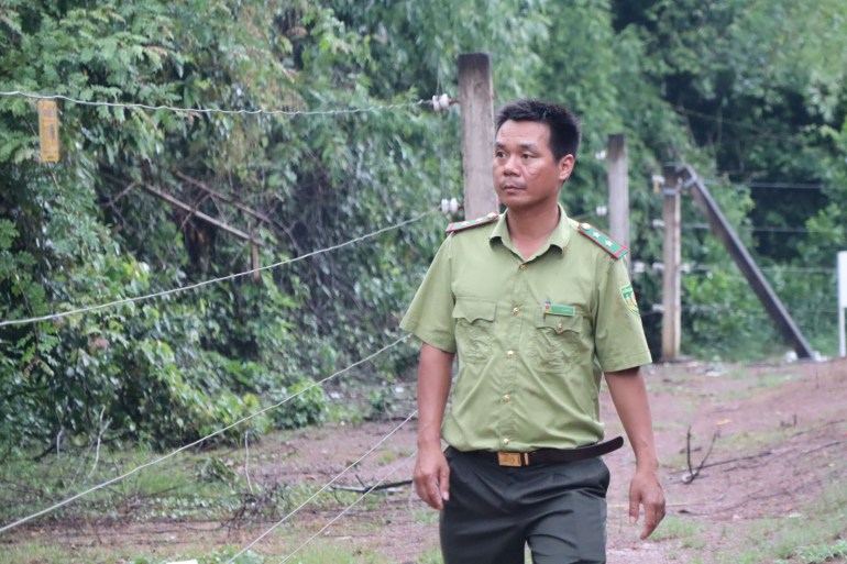 Tran Dai Nang, a forest ranger walks through part of the electric fence used to keep elephants and people out of the Dong Nai Culture and Nature Reserve. [Sen Nguyen/Al Jazeera]