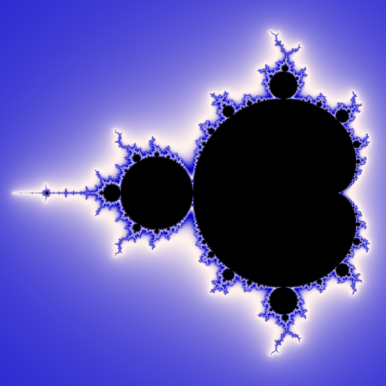 Mandelbrot set, a mathematical fractal, shown in black on a blue background.  The edges of the fractal are blue and white